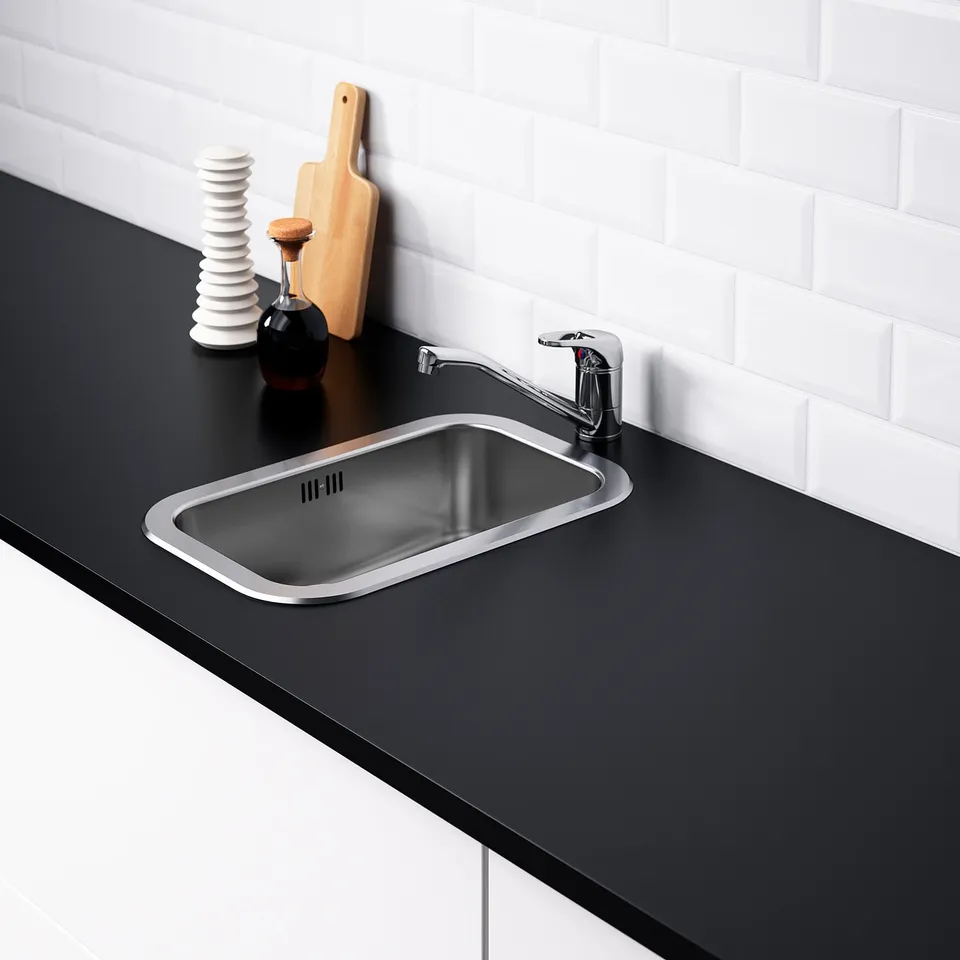 Modern kitchen sink in stainless steel with shiny tap on black countertop, featuring a sleek and functional design.