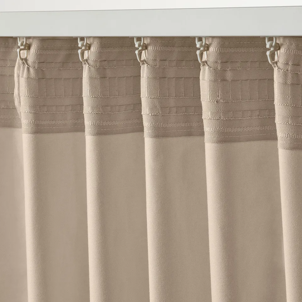 Curtains with hooks, light beige, pleated setup, filtered light function.