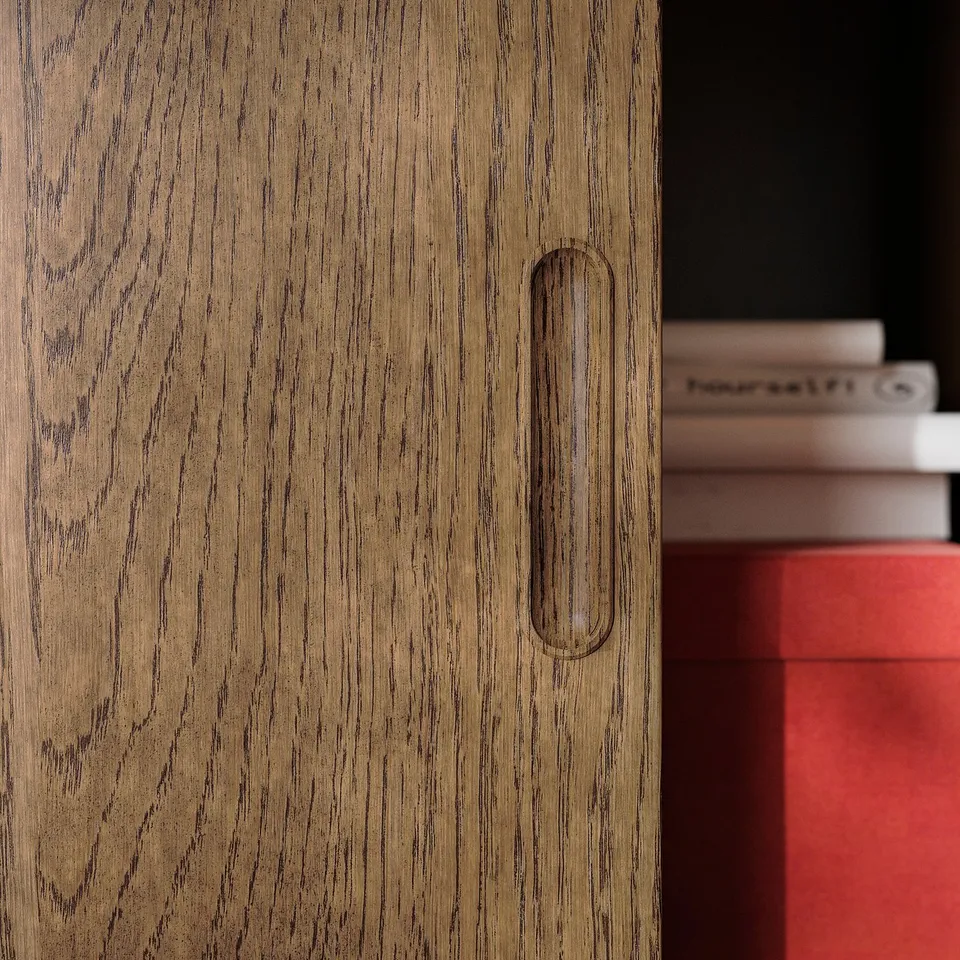 Wooden cabinet with sleek, oval handle. Grain texture and brushed veneer visible. Part of the TONSTAD series.