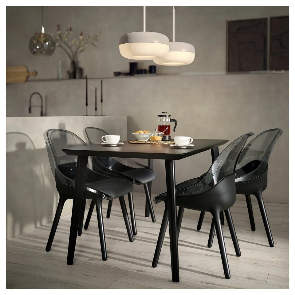 Modern dining setup with BALTSAR black chairs and wooden table, featuring sleek design and comfortable seating.