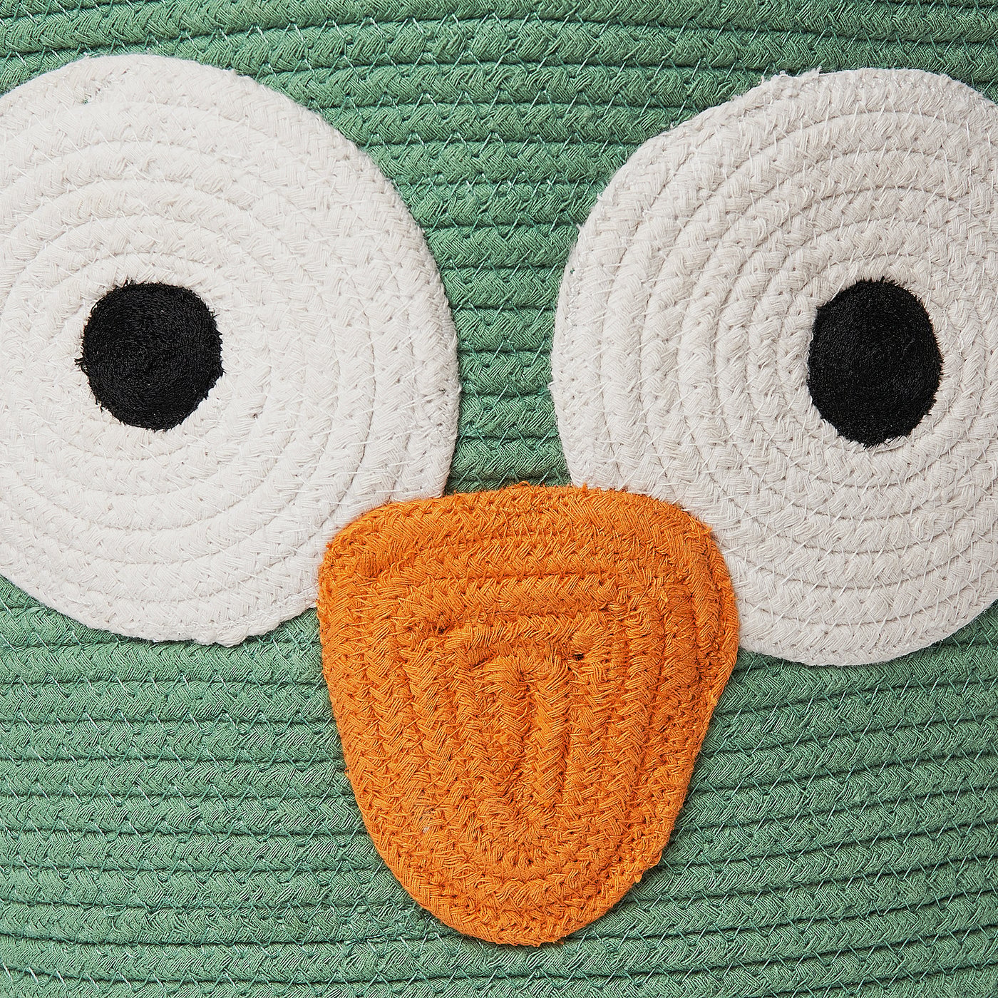 A handwoven owl-shaped storage bag made of soft, braided cotton, featuring large white eyes and a yellow-orange beak, perfect for childs room.
