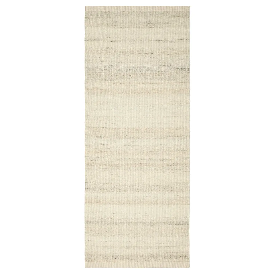 A beige TIDTABELL rug, rectangular-shaped, flatwoven with cotton and wool. Its neutral design makes it versatile for various spaces.