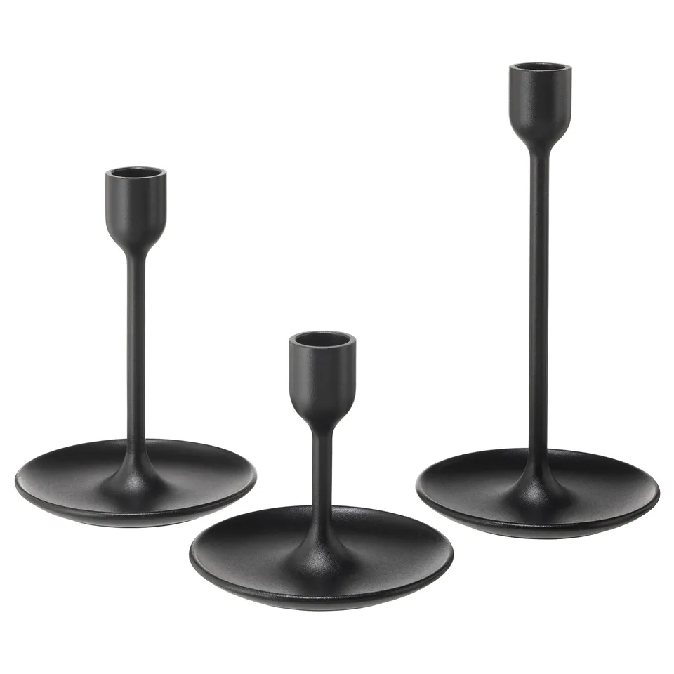 Three black minimalist candlesticks of varying heights, sleek and modern with circular bases.