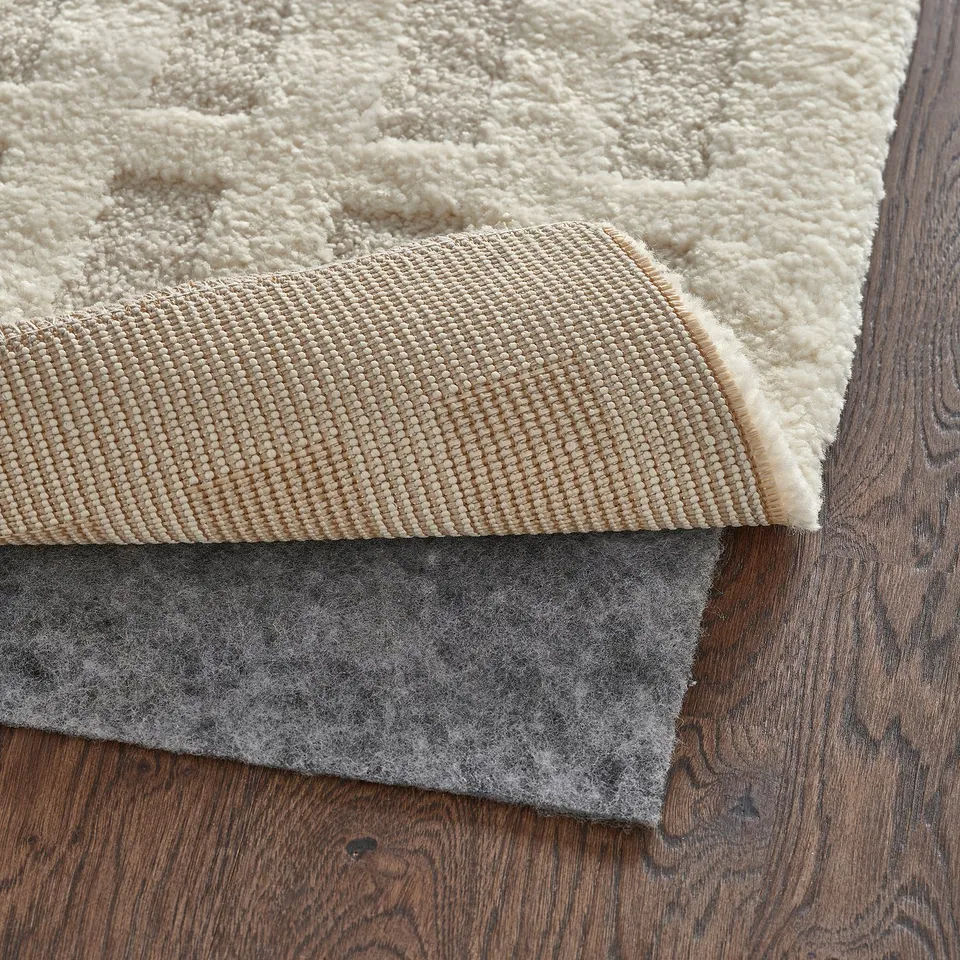 Felt rug pad under cream-colored carpet for added comfort and stability.