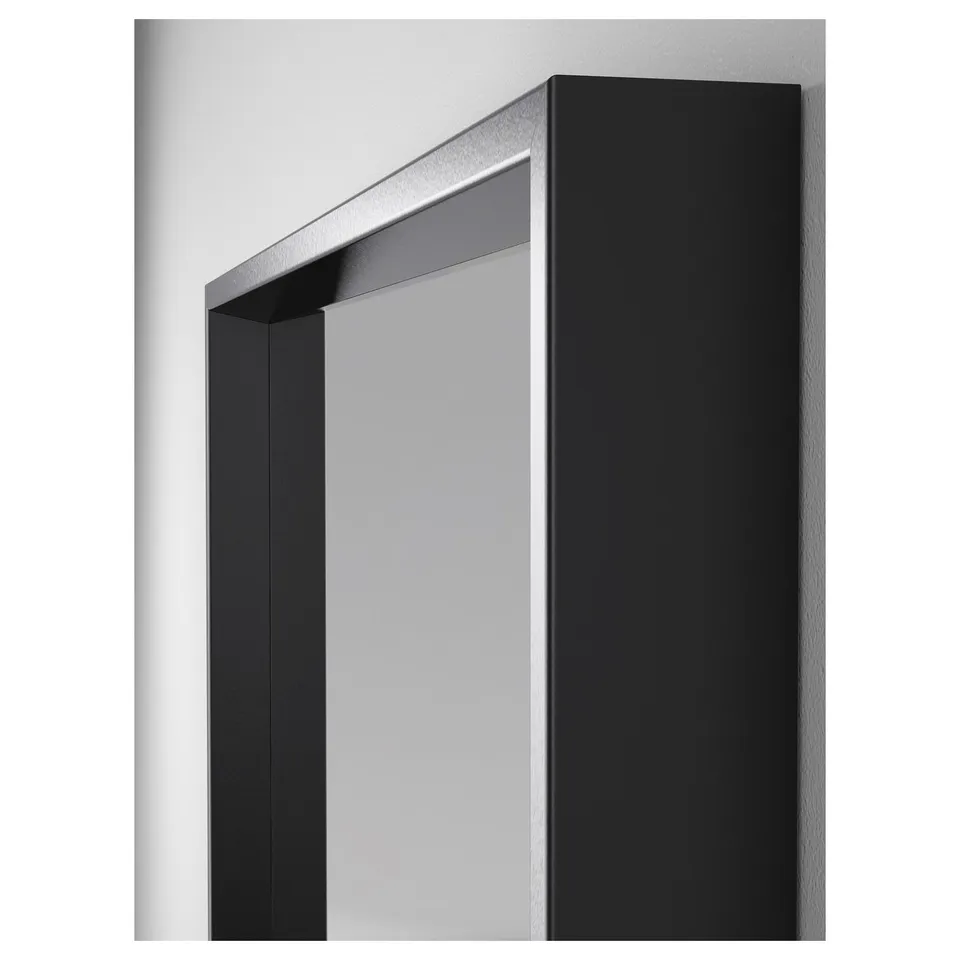 Modern, rectangular mirror with sleek black frame, designed for bathroom or bedroom use, reflecting a clean wall.