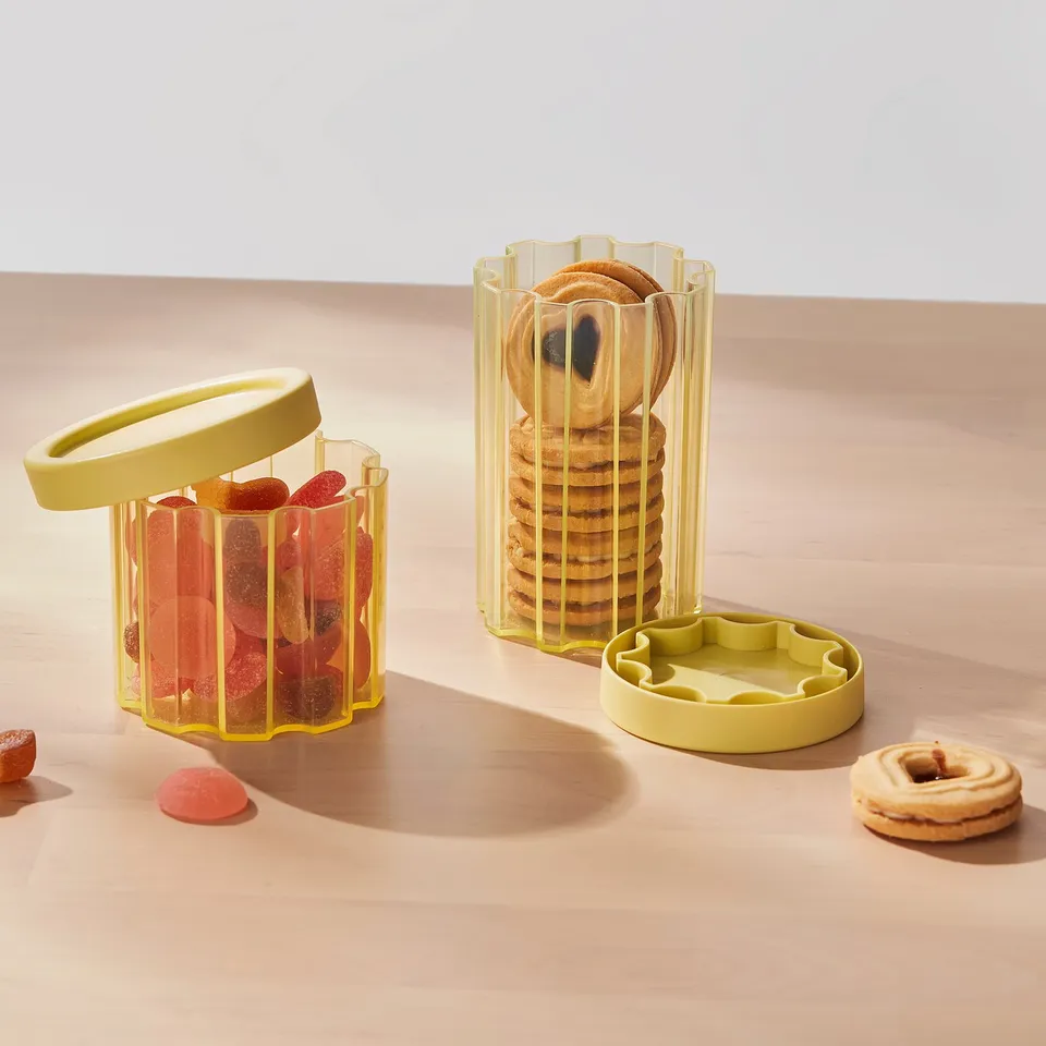 Transparent jars with yellow straps: one for cookies, one for gummies.
