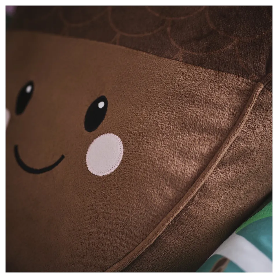 Close-up of a soft, plush acorn-shaped pillow with a smiling face, showcasing its quality texture and stitching.