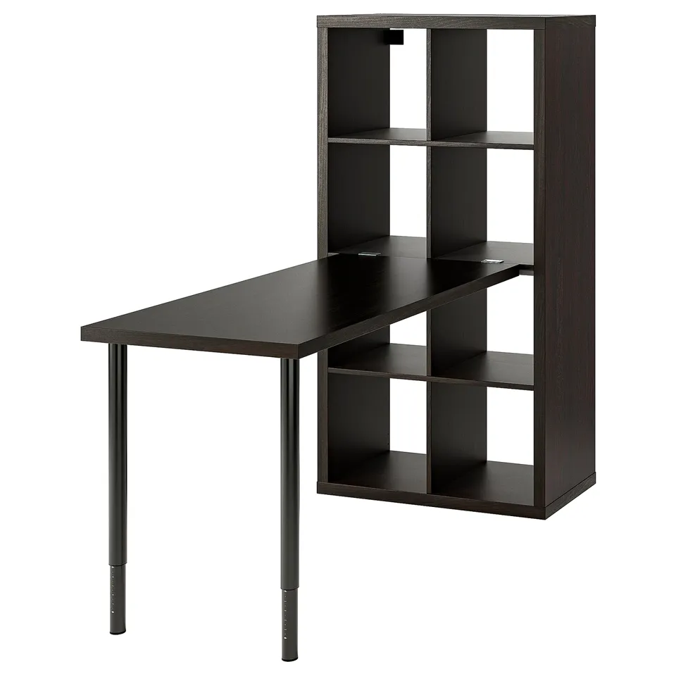 A black ikea KALLAX shelving unit with a slanted desk attached. It a dark finish and modern, functional design with open and closed storage options.