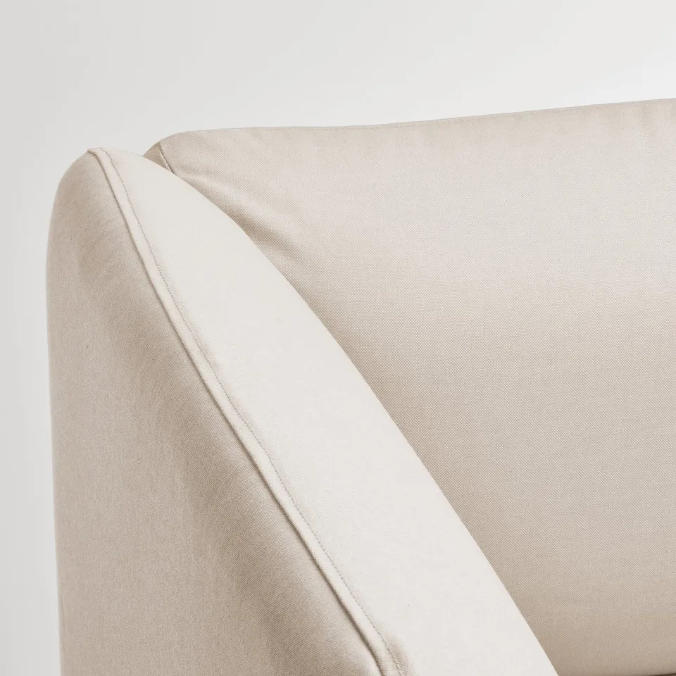 Minimalist sofa corner, smooth beige fabric, clean lines.