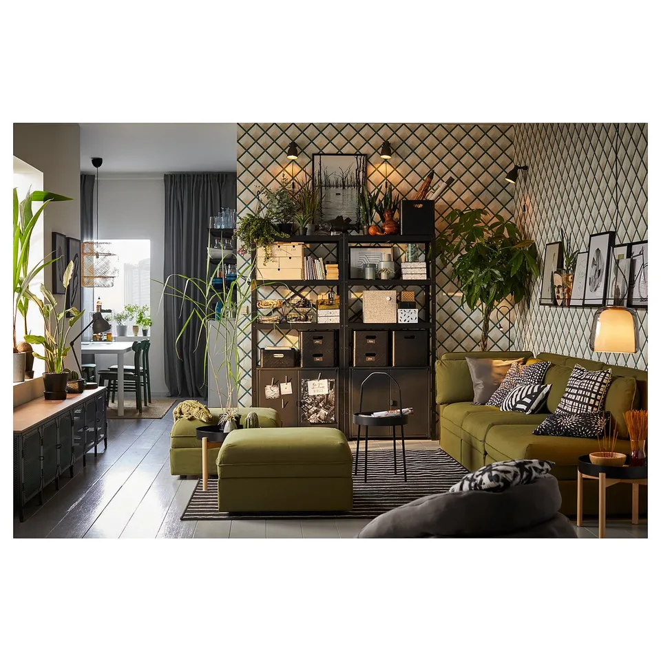 A modern living space with green furniture, black accents, and a metal storage unit.