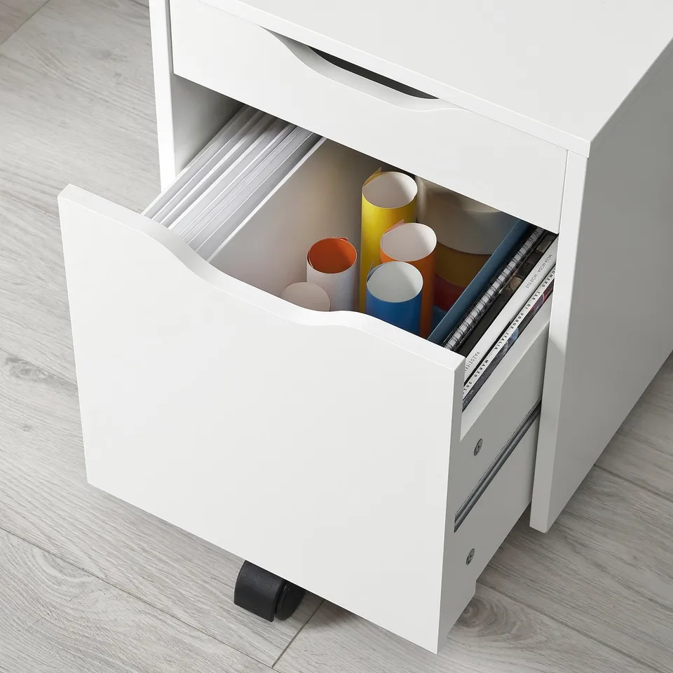 White rolling storage unit with open drawer showing colourful paper tubes.