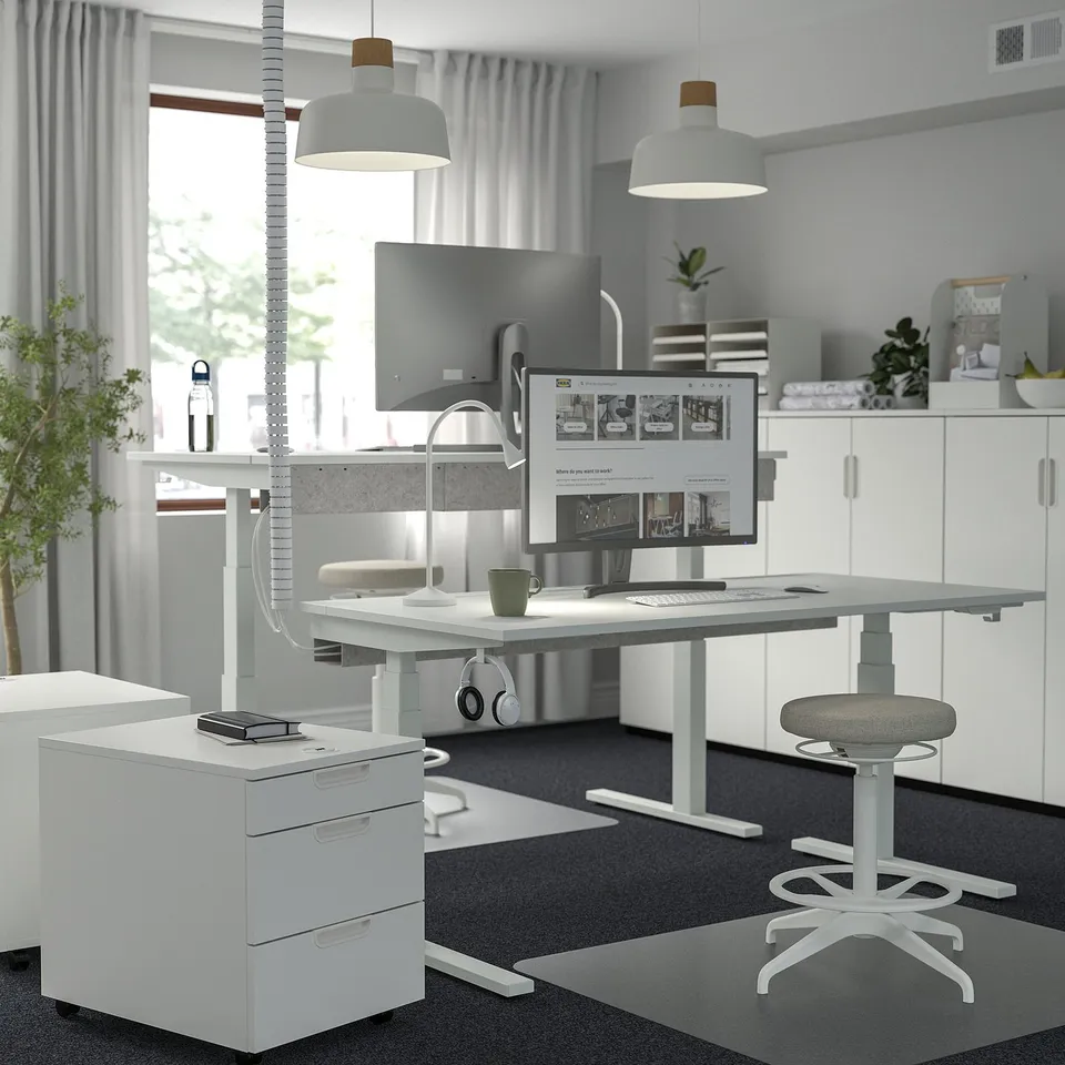 Modern home office with MITTZON desk, dual monitors, laptop, and pendant lights.