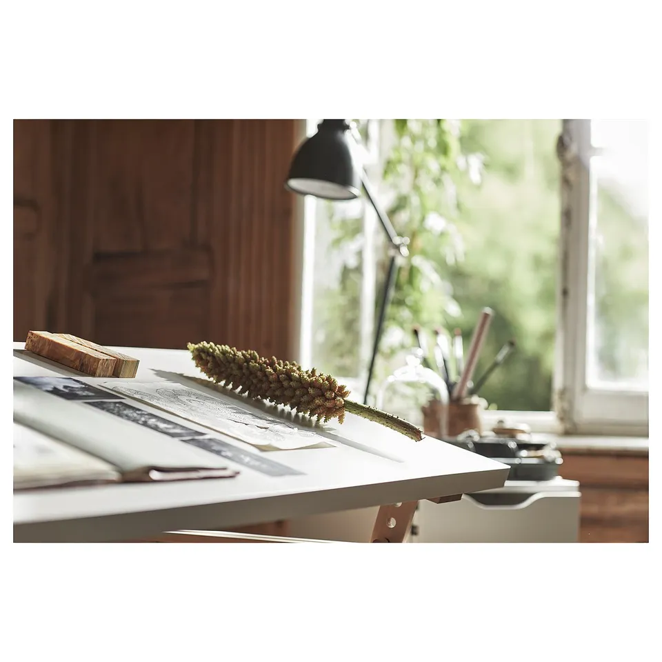 A white LAGKAPTEN desk by a window, featuring modern design, clean lines, and a mix of materials for a minimalistic look.