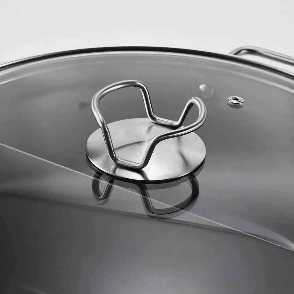 Close-up of a modern stainless steel pot lid with a robust, metallic handle, designed for even heat distribution and easy handling.