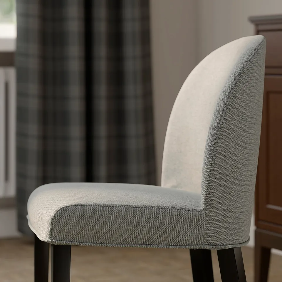 Modern chair with curved back, light grey fabric, black legs, and padded seat for comfort.