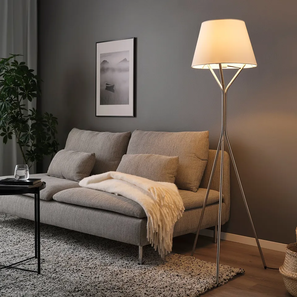 Cosy living room with grey sofa, lamp, rug, table, and wall picture.