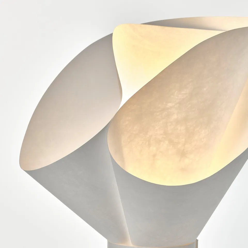 Modern, stylish lamp with soft, textured surface glowing warmly.