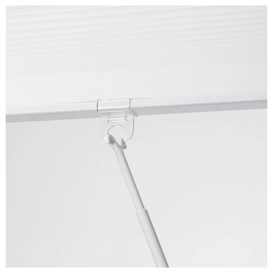 Roll-up honeycomb privacy blind with cord holder, mounted on white surface.