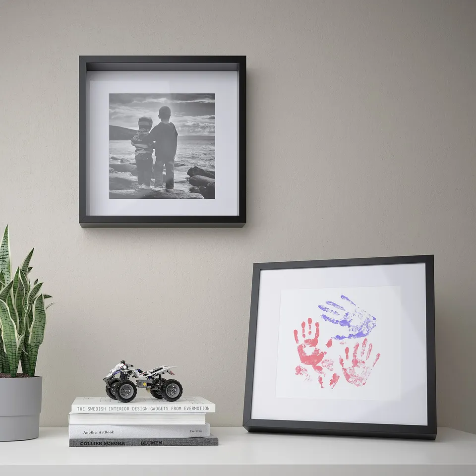 Framed sea trio, handprint art, books, motorcycle, snake plant.