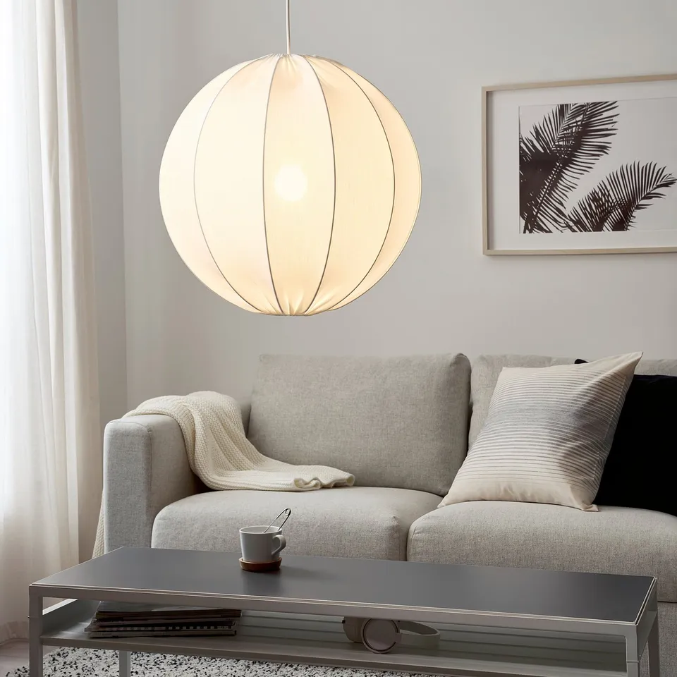 Modern living room with régnskur pendant light over grey sofa and coffee table.