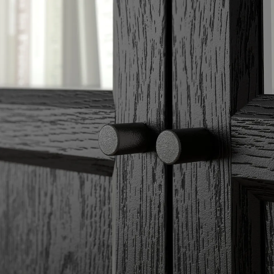 Dark wooden BILLY bookcase door, smooth metal handle, textured finish visible.