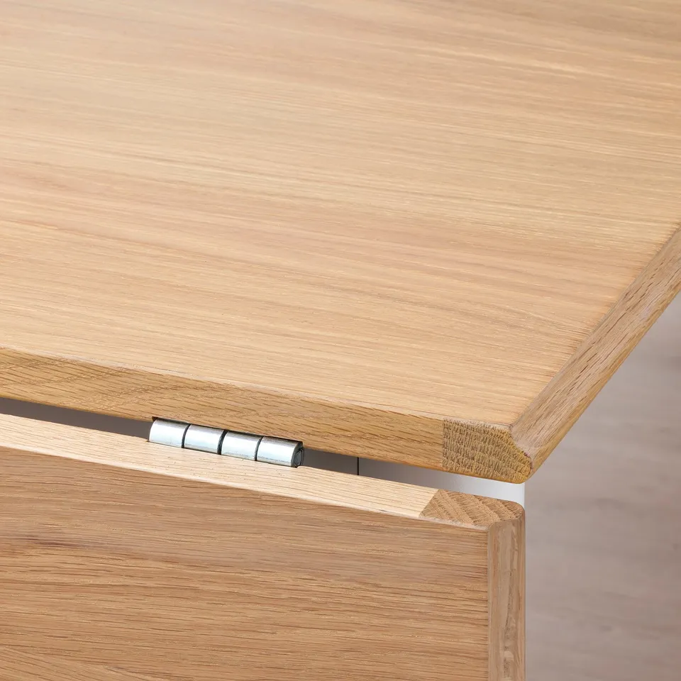 Close-up view of a wooden table joint with visible hinges and sturdy, polished wood finish.