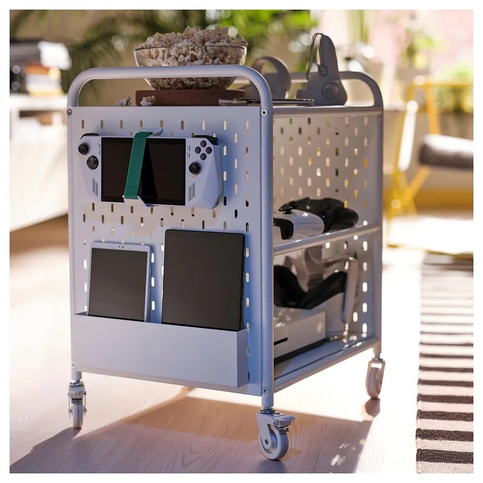BRÄNNBOLL grey gaming cart displays consoles, controllers, and headphones; fits well in room with wooden floor and striped rug.