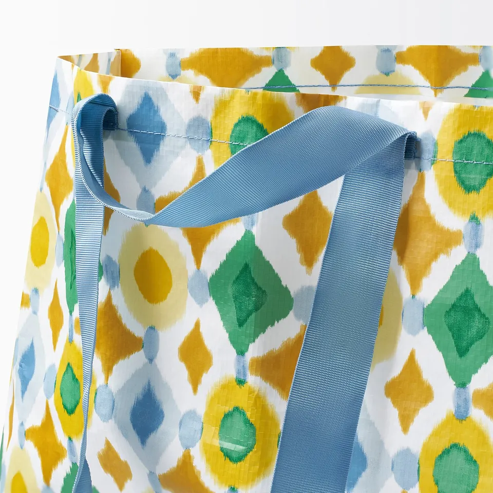 Brightly coloured patterned reusable shopping bag with strong, long handles.