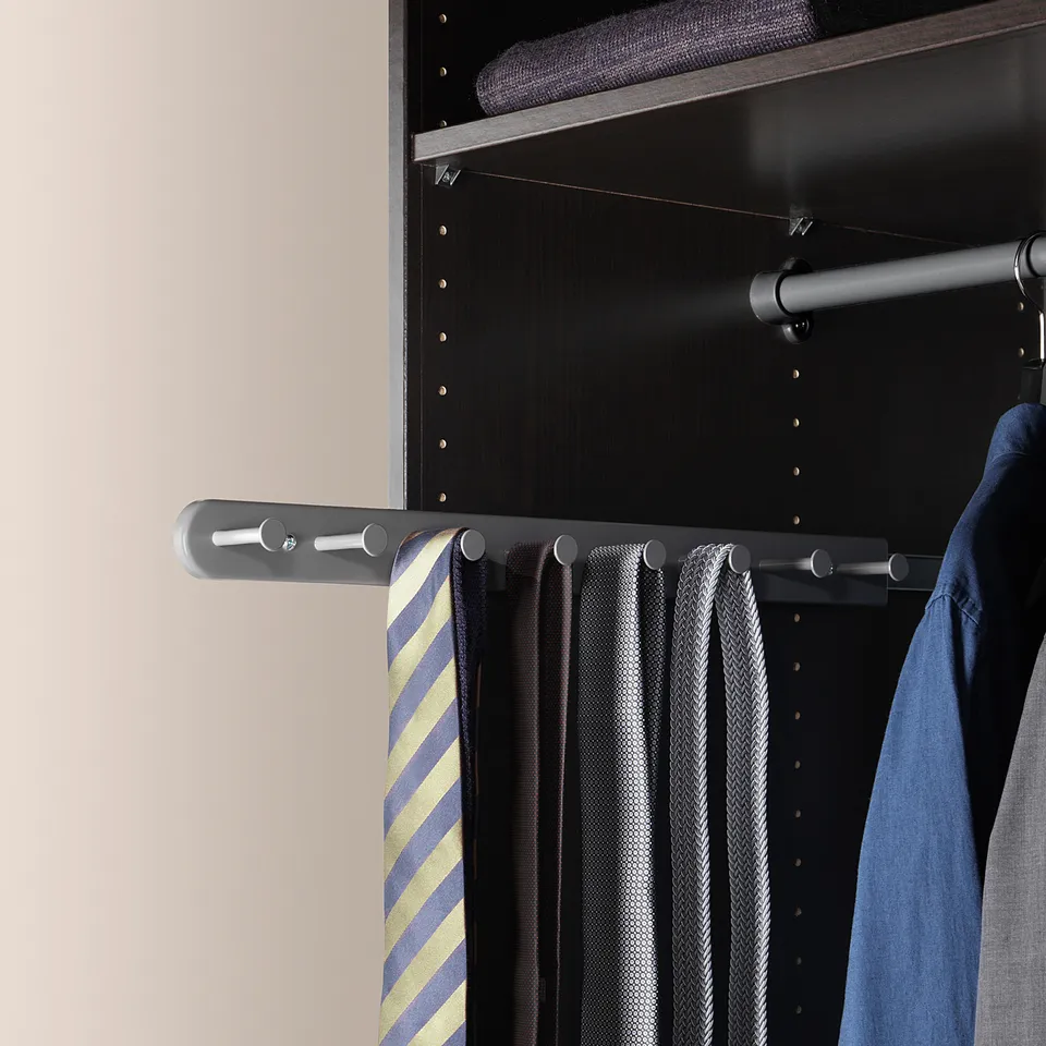 Grey closet with striped, black, and blue ties, blue shirt on metal rack.