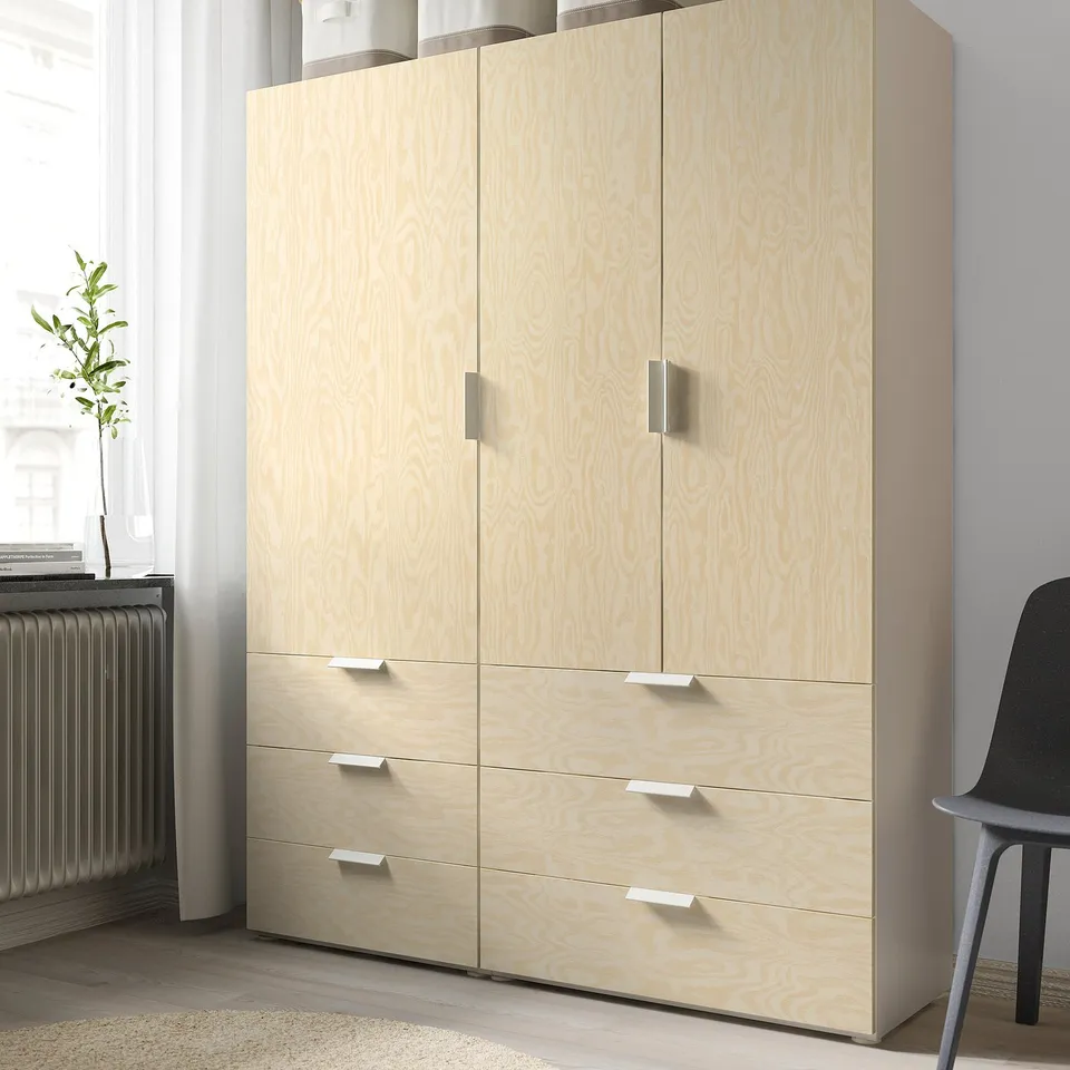 Light wooden storage unit with four drawers and two cabinets, standing against a wall.