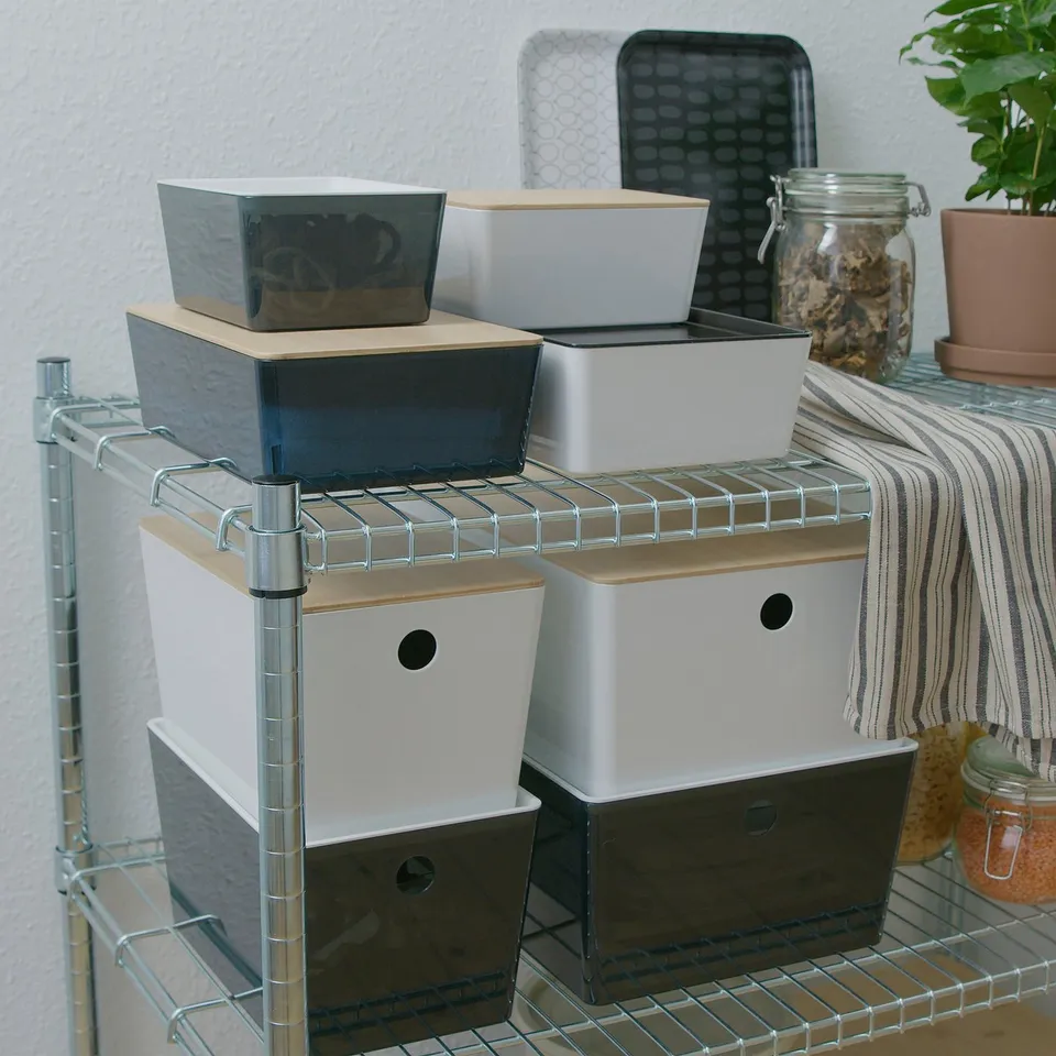 Several stacked KUGGIS boxes on shelves, sizes varying, made of bamboo and recycled pet plastic. Perfect for organising small items.