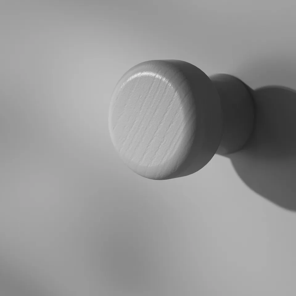 Sphere on wall hook, smooth finish, elegant design.