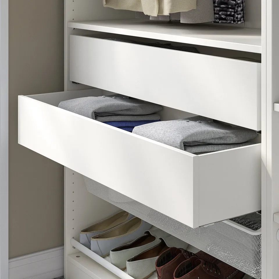 White closet drawer, holding folded clothes. Part of IKEA KOMPLEMENT series for organising wardrobe.