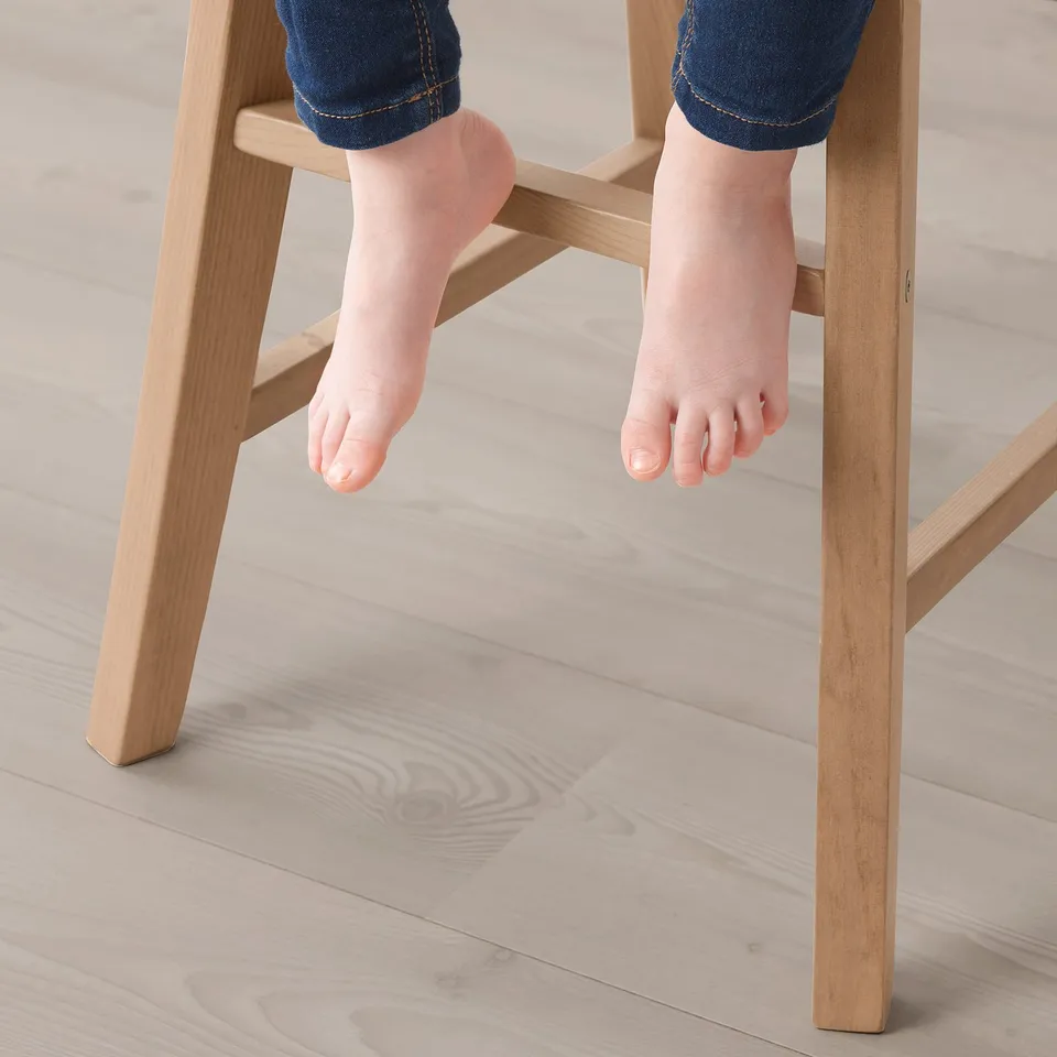 Childs feet dangling on INGOLF junior chair, showing support and comfort.