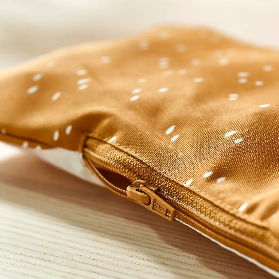 Baby support cushion with zip, tan with white dots.