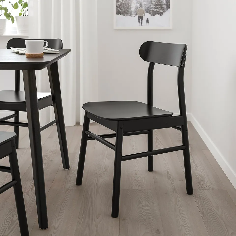 Modern black LISABO chair and table set for dining in minimalist setting.