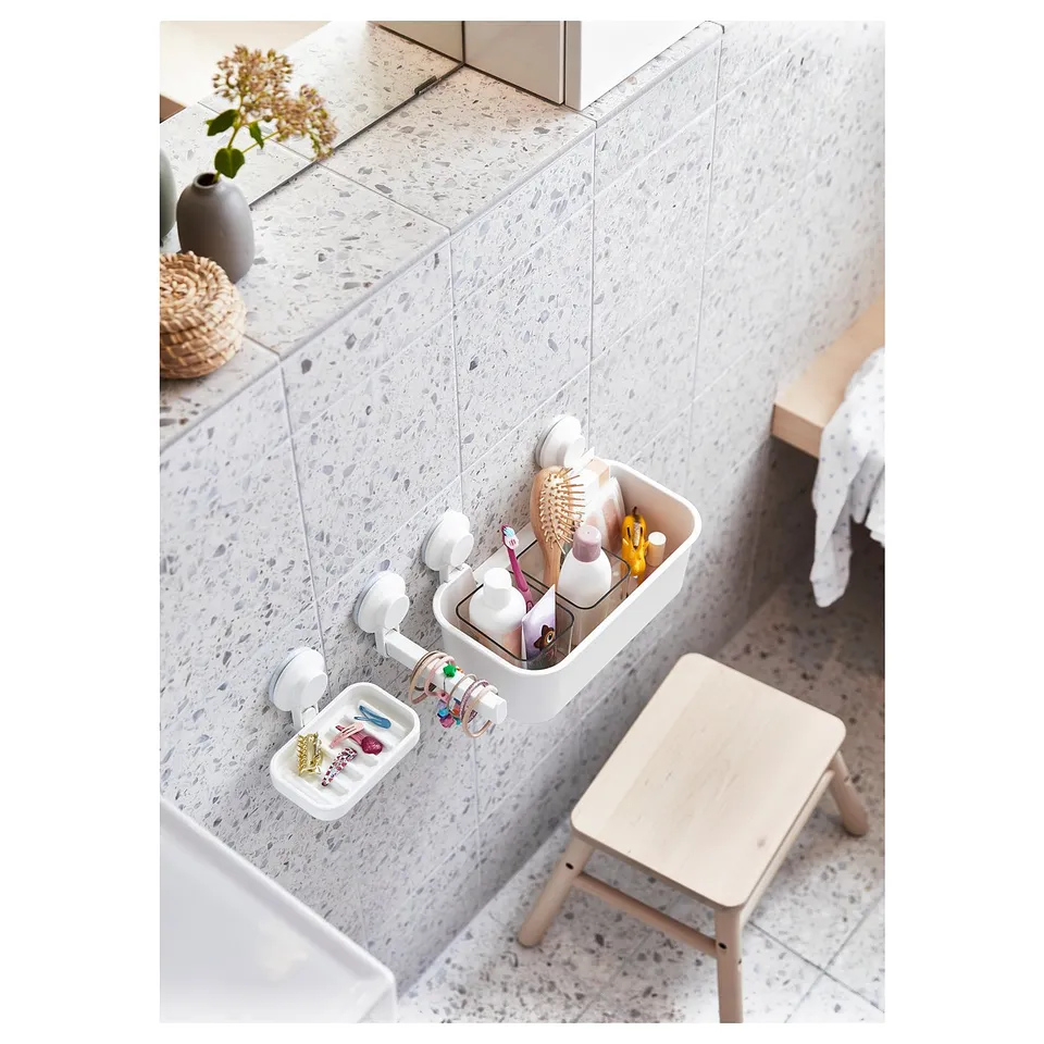Bathroom organiser: white TISKEN suction cup holder with compartments for toiletries and jewellery. Mounted on tiled wall.