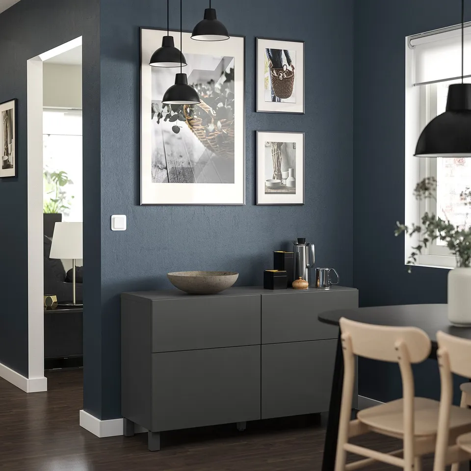 Modern living room with dark blue walls, featuring BESTÅ storage unit in dark grey with minimalist decor.