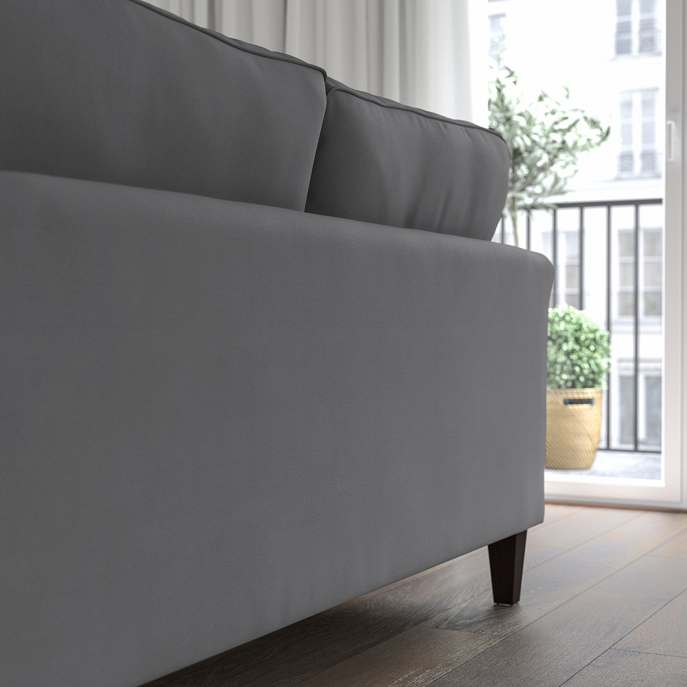 Grey EKHOLMA sofa near window with plant. Upright seating, soft cushions, removable cover.