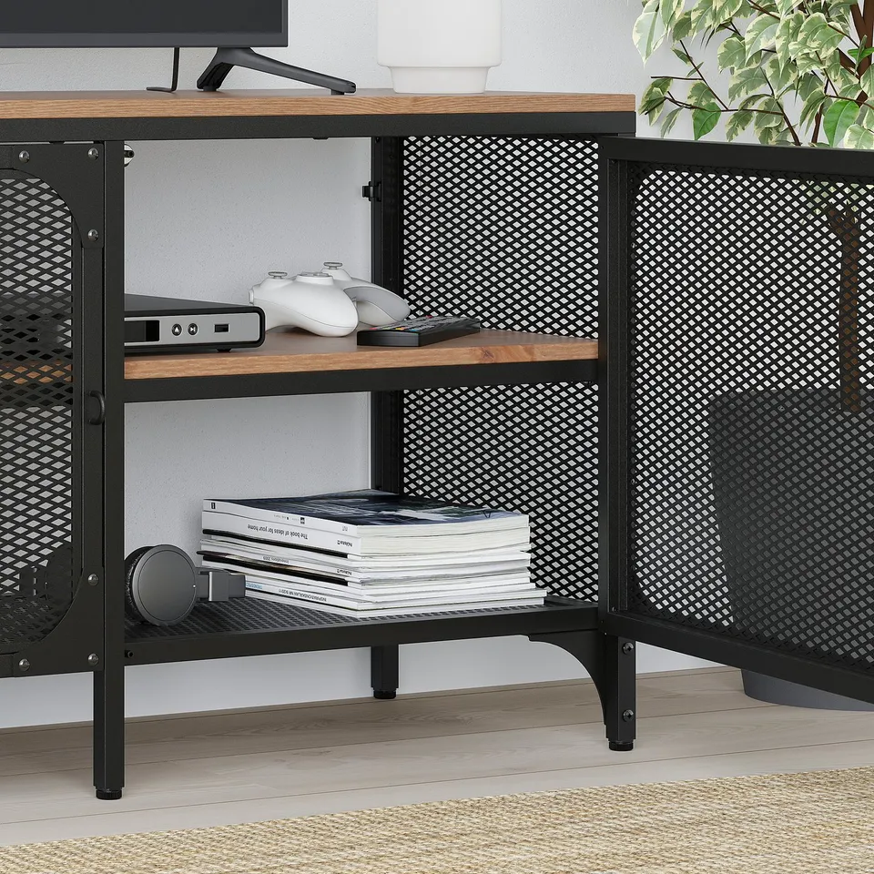Industrial tv stand with rustic wood shelves holding gaming consoles, controllers, and magazines.
