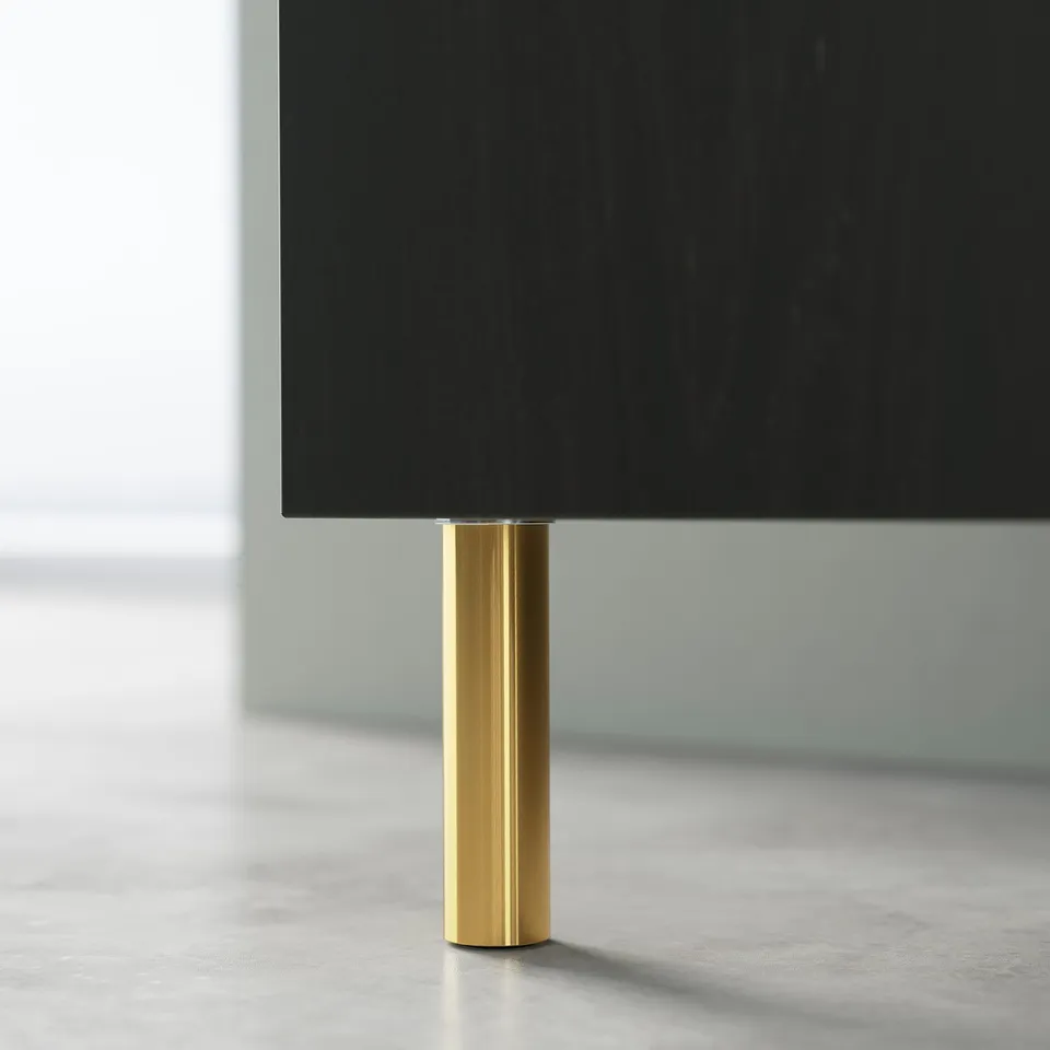 Modern black tv on gold stand. Sleek, minimalist design. Metallic gold cylindrical base.