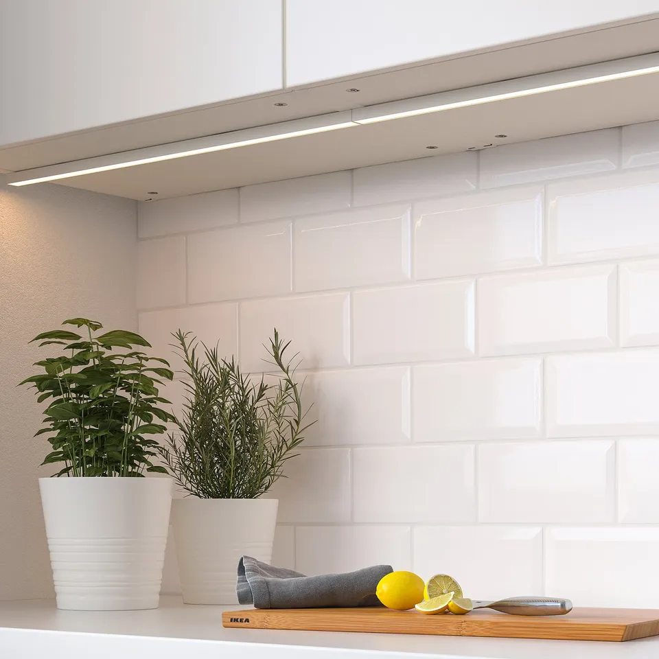Kitchen counter with plants, light, lemon, knife.