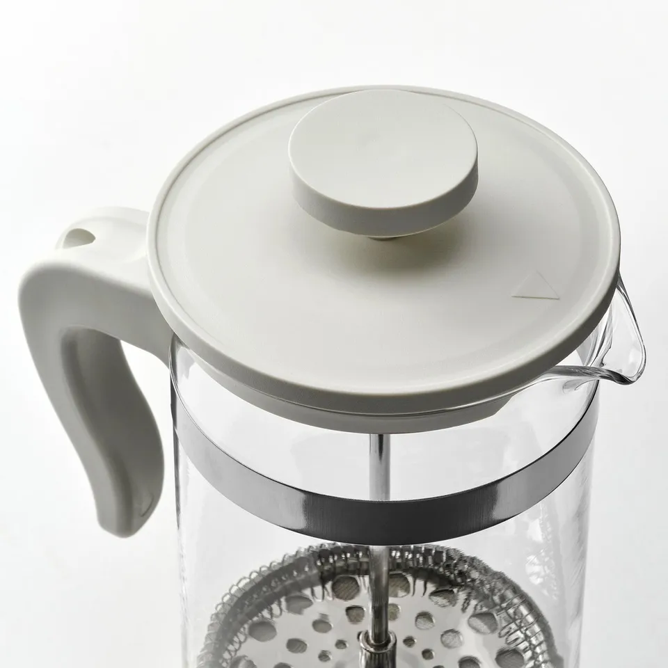 Coffee press with silver accents, white handle, brews coffee/tea.