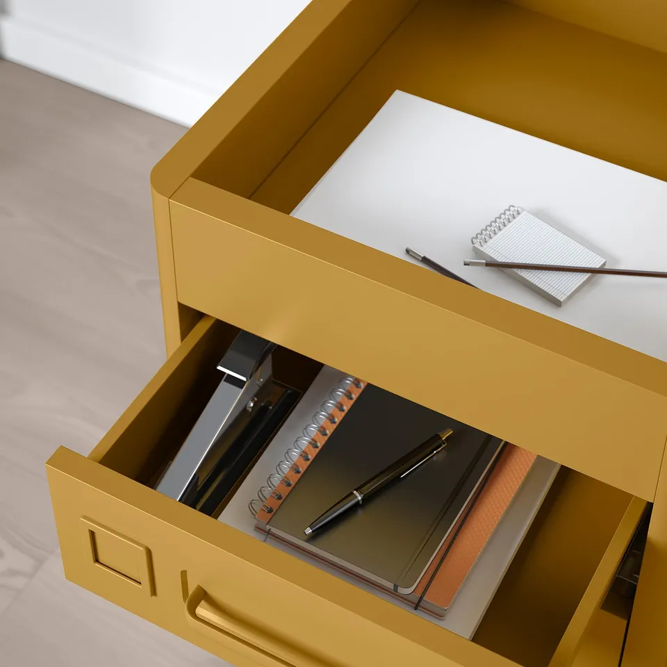 Yellow desk with open drawers showing stationery: pen, notepads, and organised compartments.