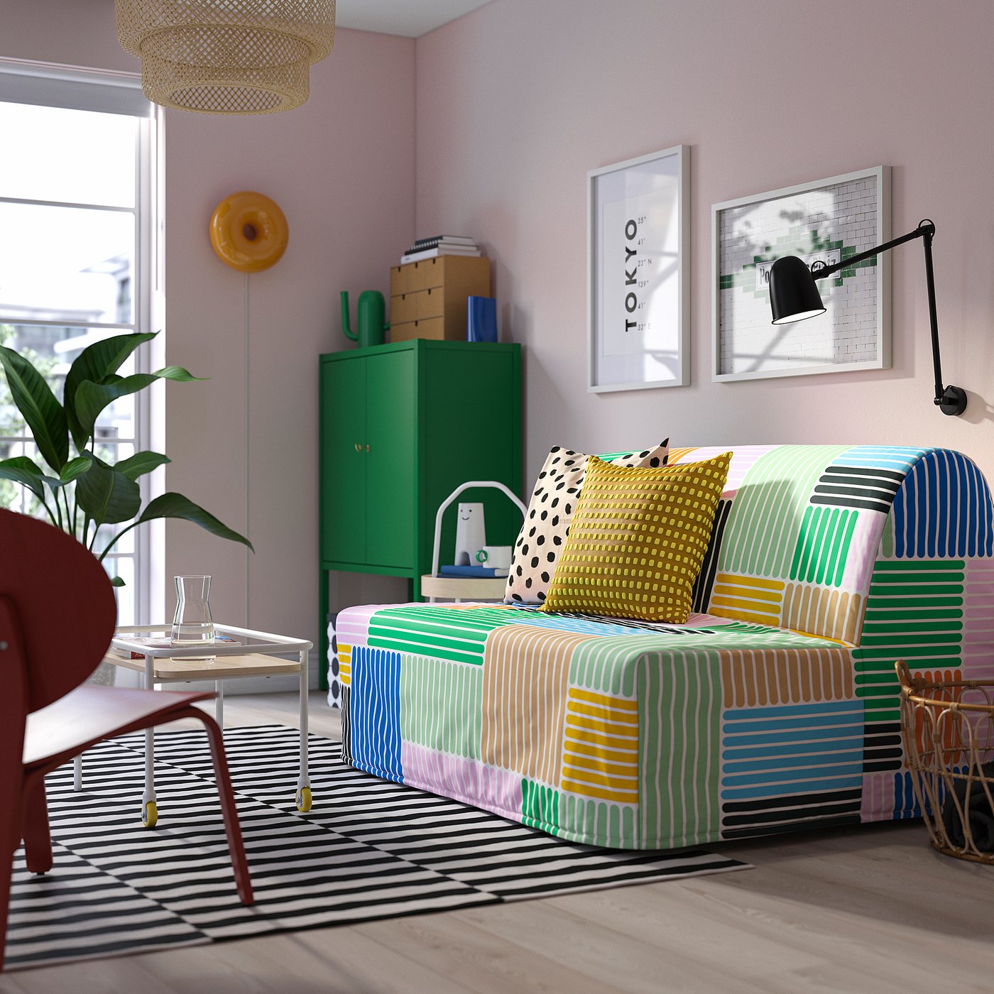 Bright, multicoloured striped sofa in lively room. Surrounded by green cabinet, wall art, and natural light.
