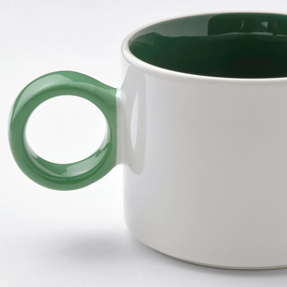 White mug, green handle.