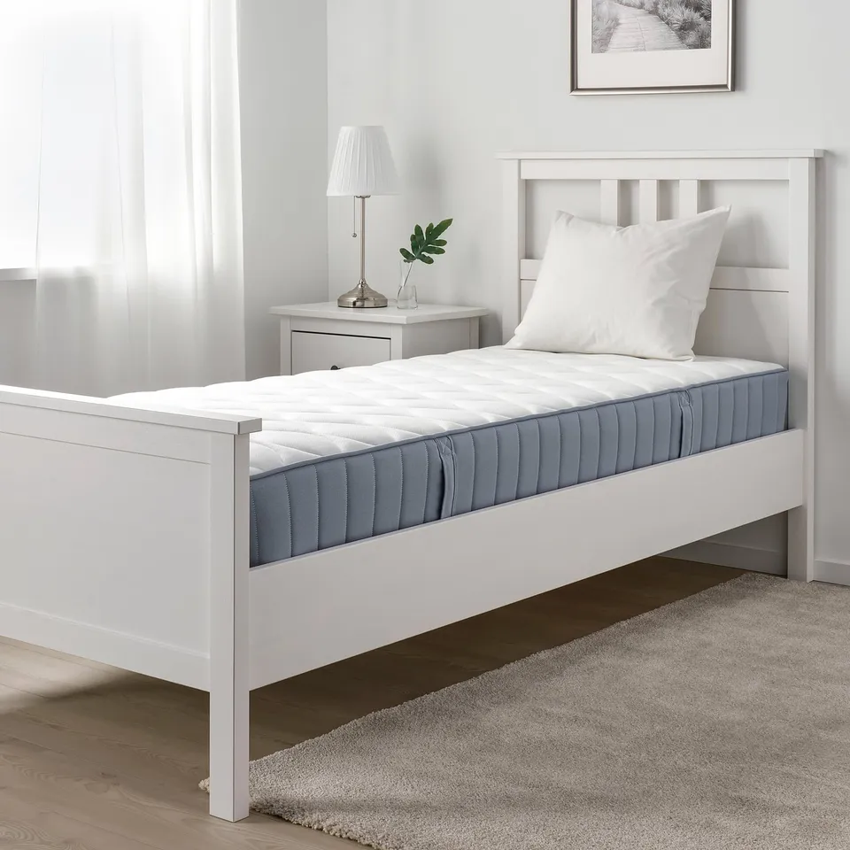 Minimalist bedroom with VÅGSTRANDA twin bed, bedside table, and lamp.