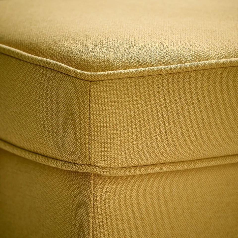 Soft, curved yellow chair with smooth fabric, showcasing high-quality comfort and design.