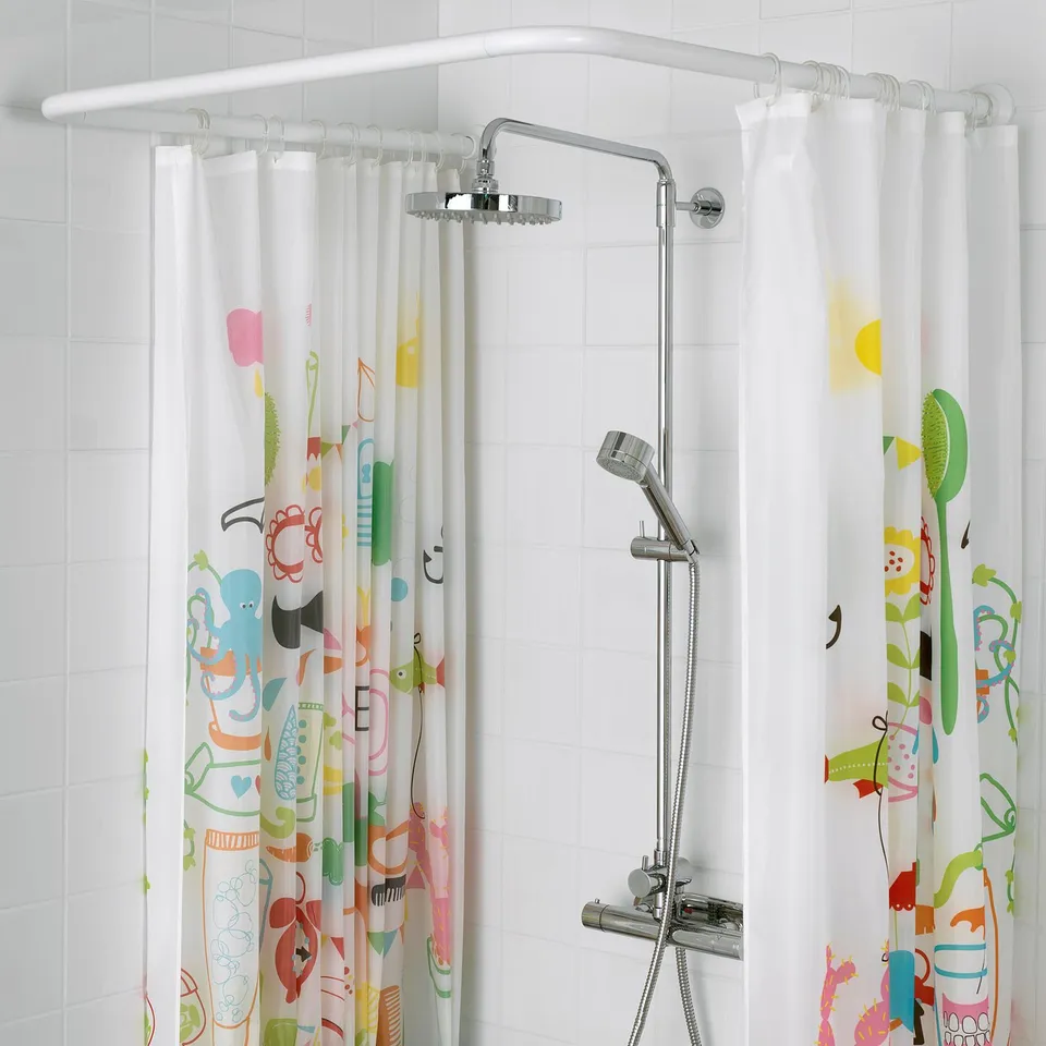 Modern bathroom with VIKARN corner shower curtain rod holding colourful curtain.