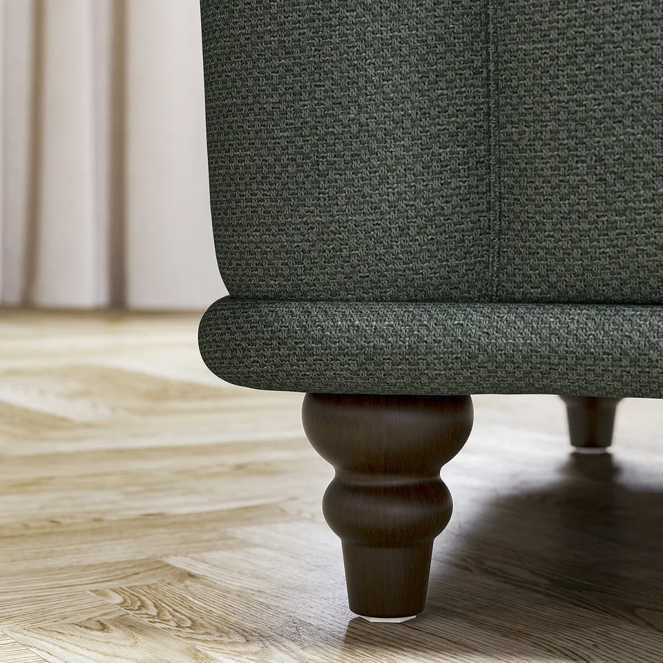 A close-up of a green VISKAFORS sofas leg, featuring a classic design with wooden support.